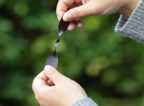 검은색 플라스틱 소재 샘플을 양손으로 잡아 늘리고 있는 모습. 노보루프의 OISTRE™ TPU 소재의 인장 강도 또는 탄성을 테스트하는 장면.